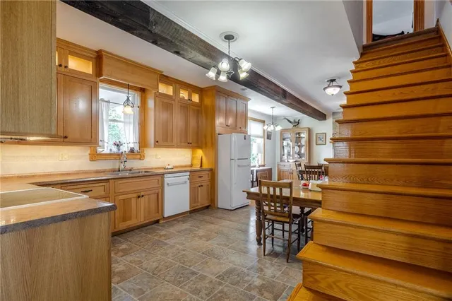 a dining room with wooden floor a chandelier a wooden table and chairs