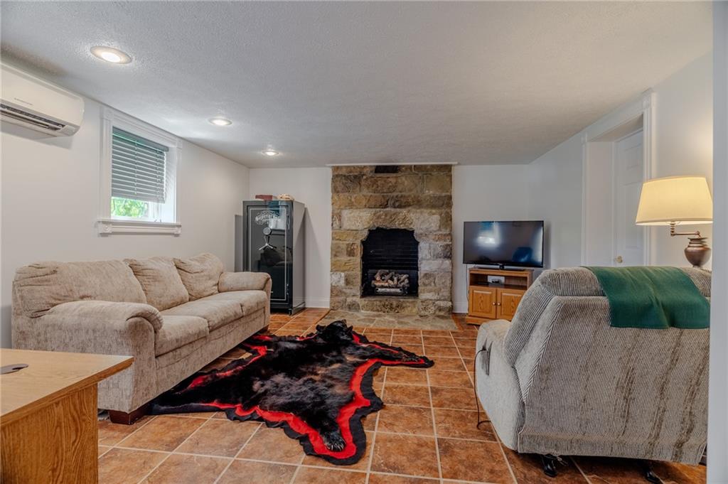 440 Owl Hollow Road Ligonier, PA 15658 - Photo 32 of 49 a living room with furniture flat screen tv and a fireplace