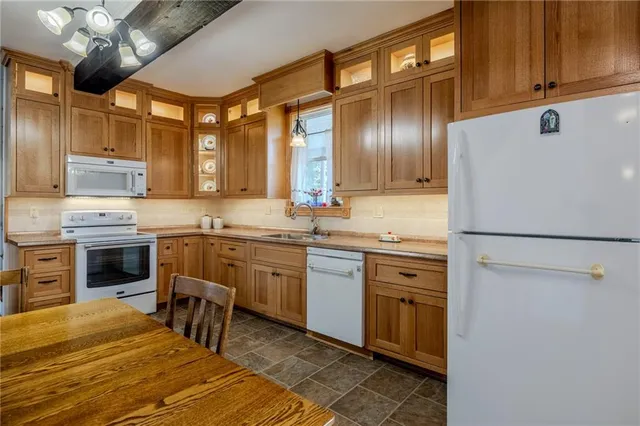 a kitchen with stainless steel appliances granite countertop a sink and a refrigerator