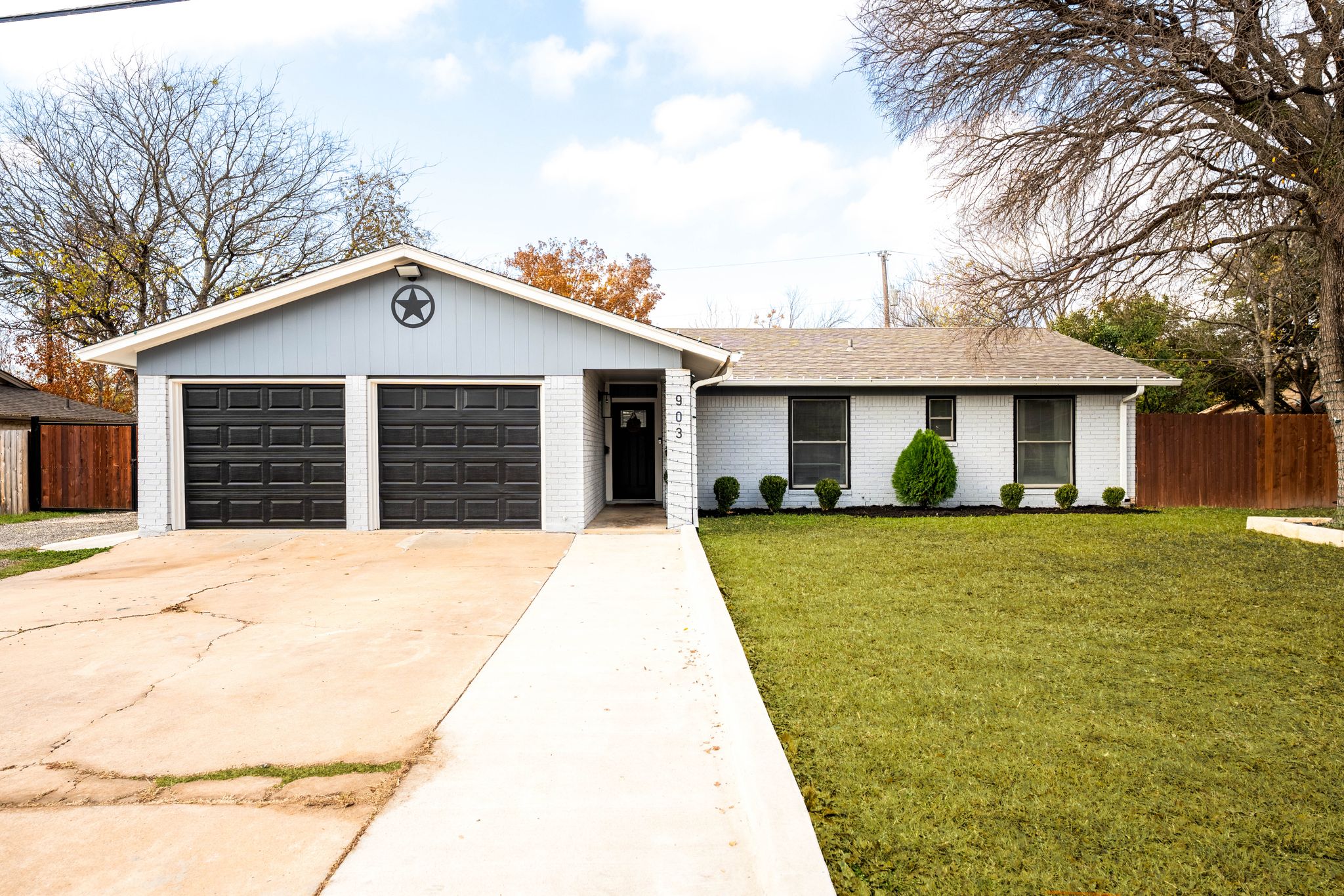 Ranch-style home with brick siding, driveway, a garage, and roof with shingles