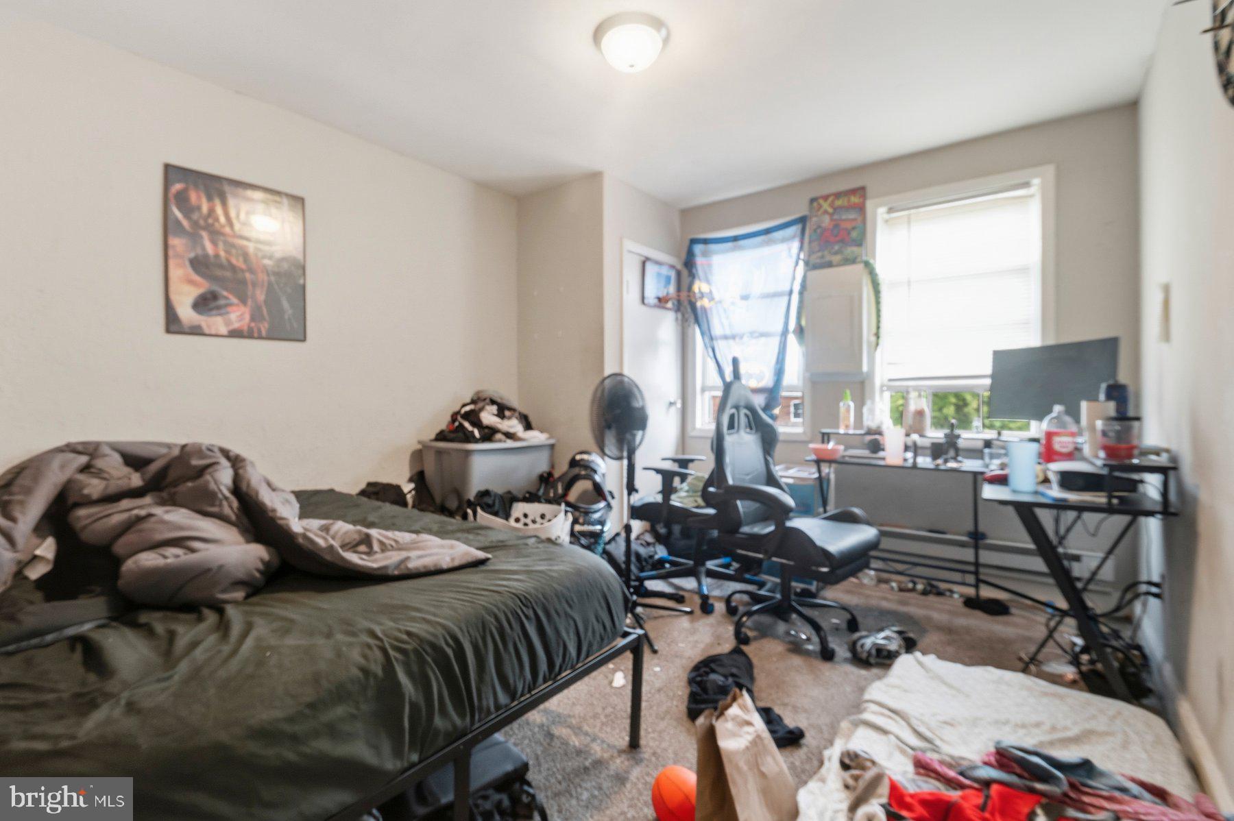 4931 Brookwood Road Baltimore, MD 21225 - Photo 13 of 25 a bedroom with a bed a large window and chair