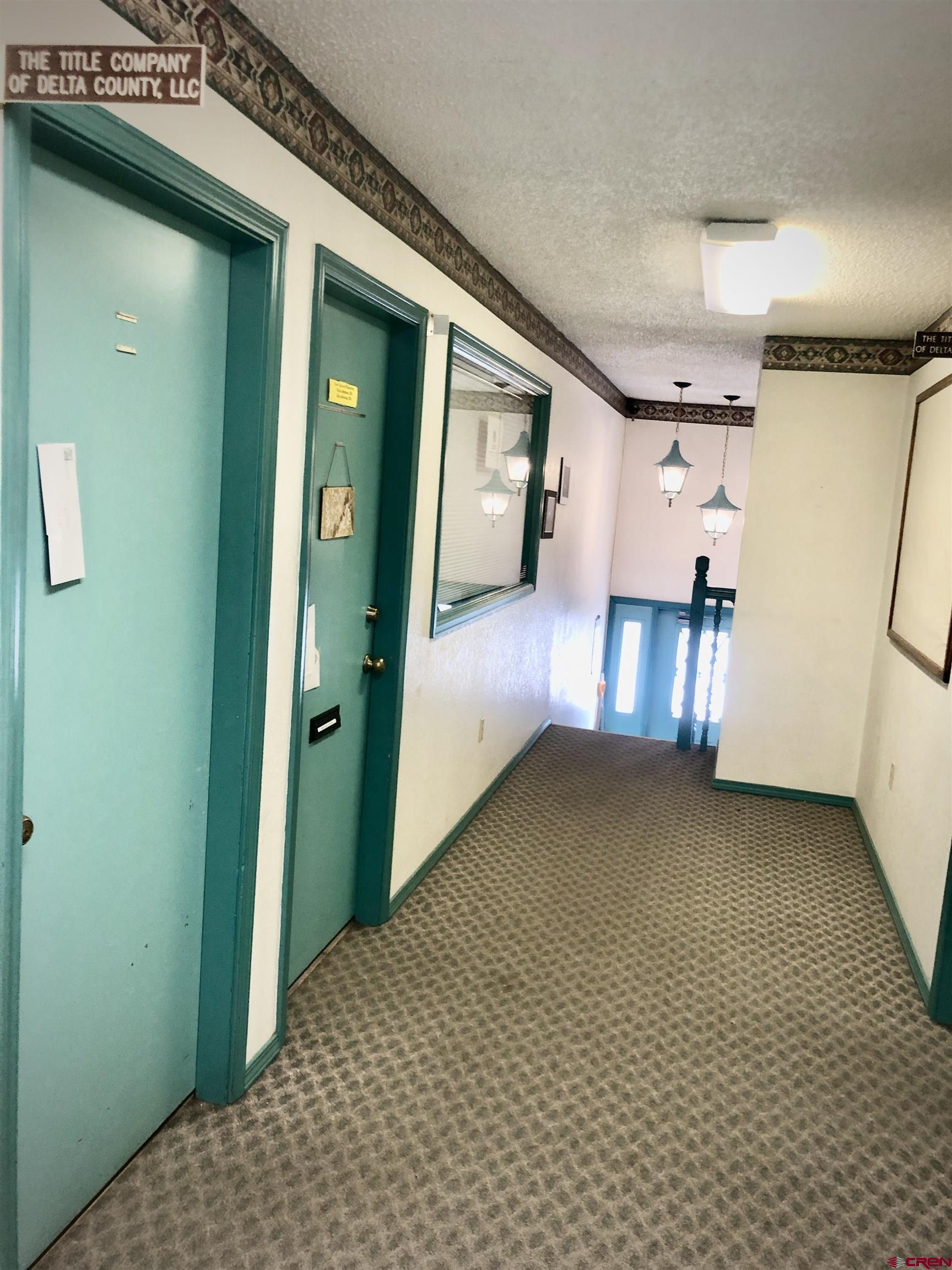 721 Main Street Delta, CO 81416 - Photo 9 of 17 a view of a hallway to room with wooden floor and stairs