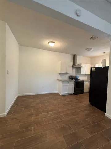 a view of kitchen with granite countertop cabinets and refrigerator