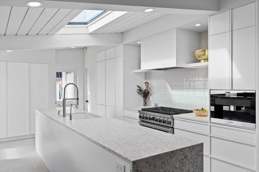 5972 Avenida Chamnez La Jolla, CA 92037 - Photo 3 of 9 a kitchen with kitchen island a sink stainless steel appliances and cabinets