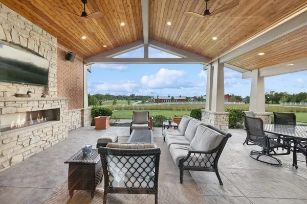 a living room with furniture large windows and wooden floor