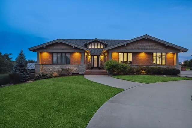 a front view of a house with a yard and potted plants