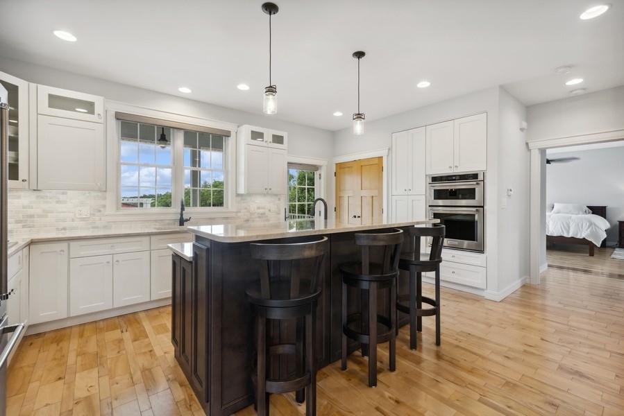 12243 179th Street Mokena, IL 60448 - Photo 54 of 101 a kitchen with stainless steel appliances granite countertop a refrigerator a sink dishwasher a stove and white cabinets with wooden floor