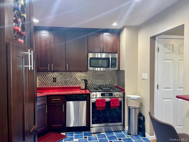 a kitchen with stainless steel appliances granite countertop a refrigerator and a stove