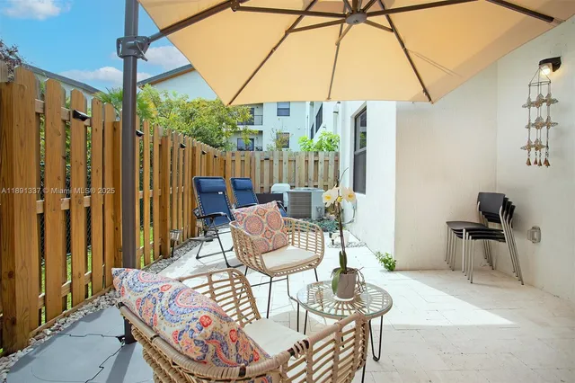 a view of a patio with a table and chairs under an umbrella
