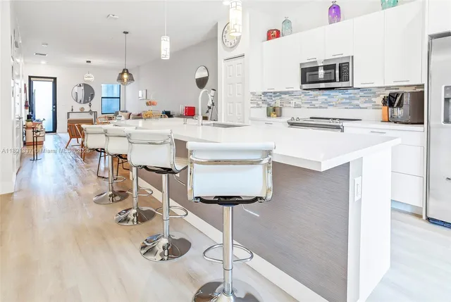 a kitchen with stainless steel appliances kitchen island granite countertop a sink and cabinets