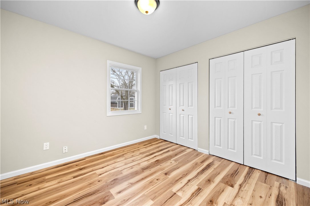 12452 Island Road Grafton, OH 44044 - Photo 20 of 39 Unfurnished bedroom featuring two closets and light wood-style floors