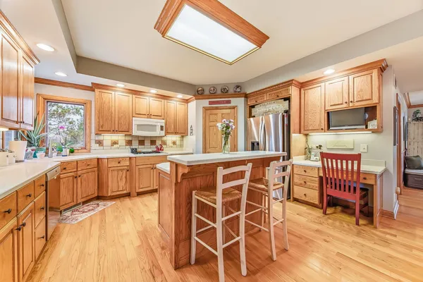 a kitchen with stainless steel appliances wooden floor dining table and chairs