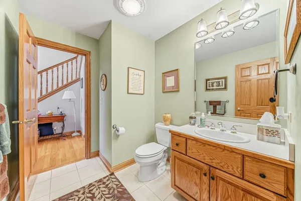 a spacious bathroom with a toilet a sink and a mirror
