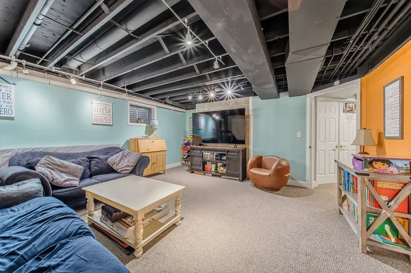 a living room with furniture a flat screen tv and a chandelier
