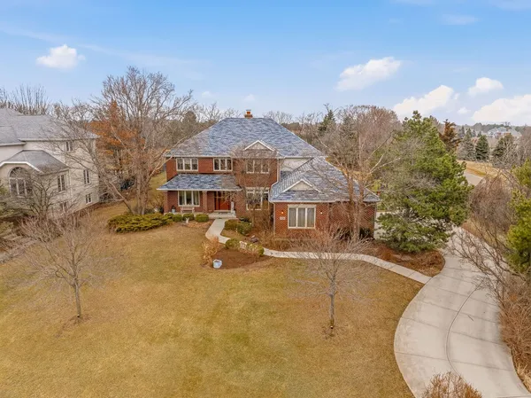 a view of a big house with a big yard and large tree