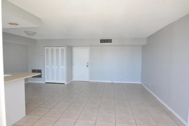 a view of an empty room with kitchen