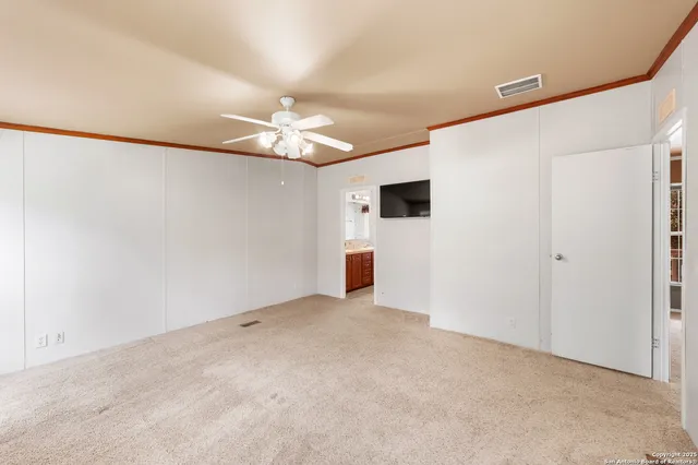 an empty room with a ceiling fan and a window