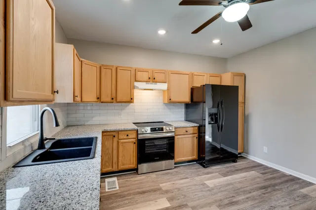 a kitchen with stainless steel appliances granite countertop a stove a sink and a microwave