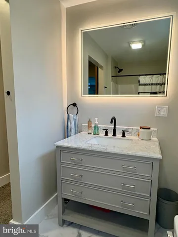 a view of bathroom with a sink and mirror