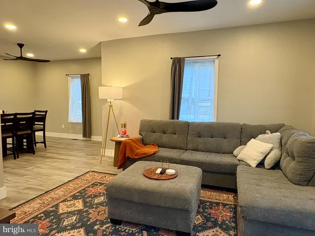 a living room with furniture and a wooden floor