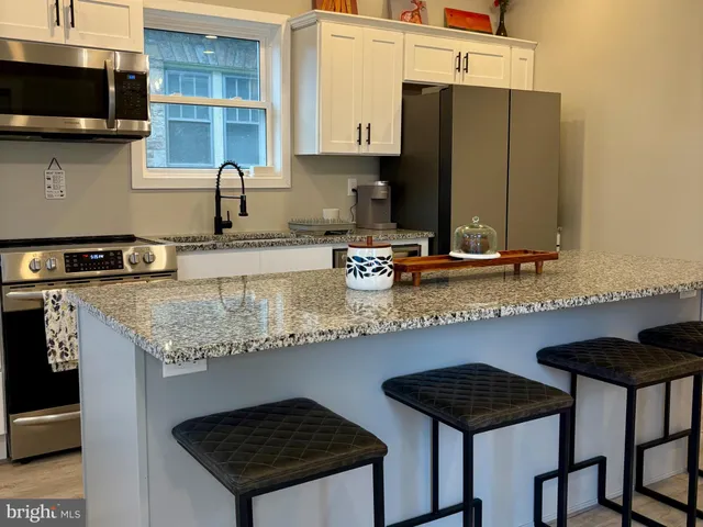 a kitchen with stainless steel appliances granite countertop a sink stove and cabinets