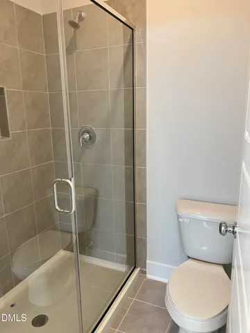 a white toilet sitting next to a bath tub and shower