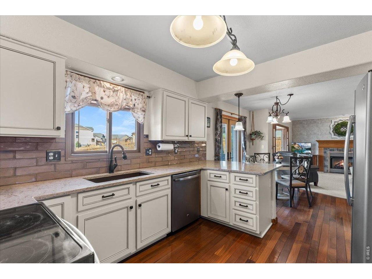 537 South 9th Street Berthoud, CO 80513 - Photo 11 of 47 a kitchen with stainless steel appliances granite countertop a sink cabinets and wooden floor