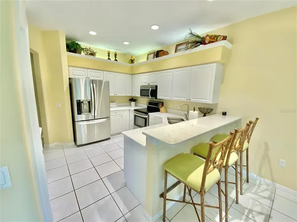 a kitchen with stainless steel appliances kitchen island granite countertop a refrigerator and a stove top oven