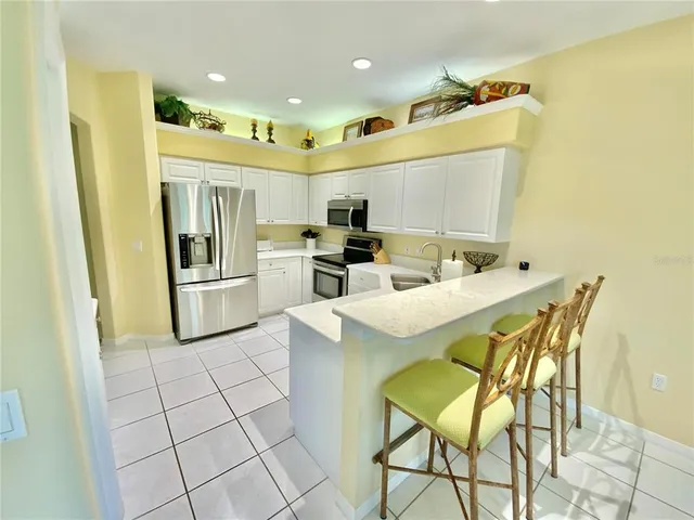 a kitchen with stainless steel appliances kitchen island granite countertop a refrigerator and a stove top oven