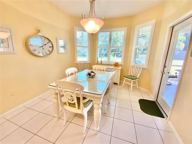 a dining room with furniture and a large window
