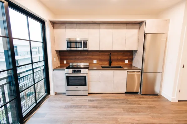 a kitchen with stainless steel appliances a refrigerator sink and microwave