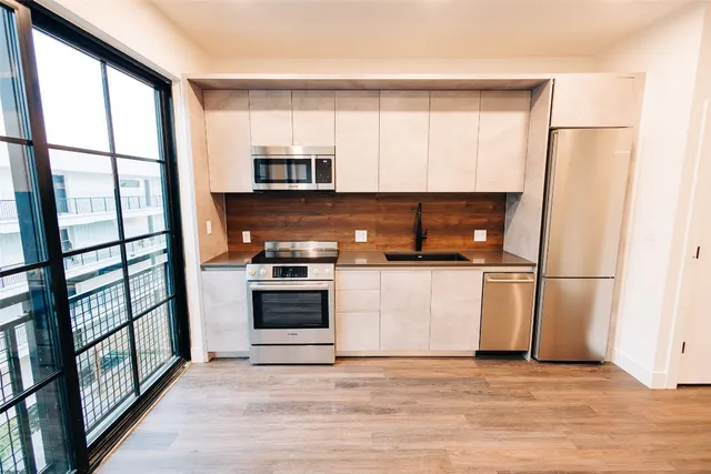 a kitchen with stainless steel appliances a refrigerator sink and microwave