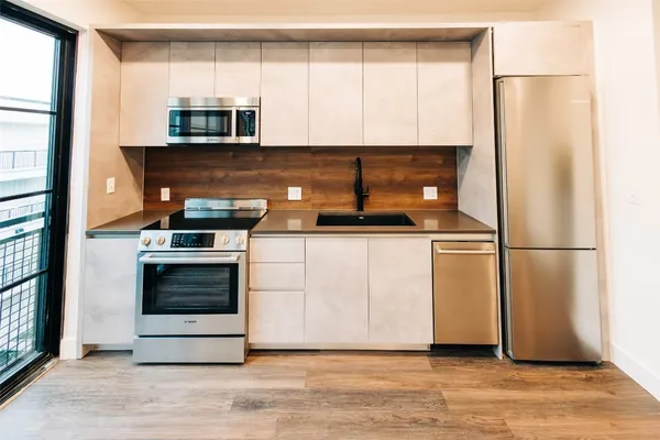 a kitchen with stainless steel appliances a refrigerator sink and microwave