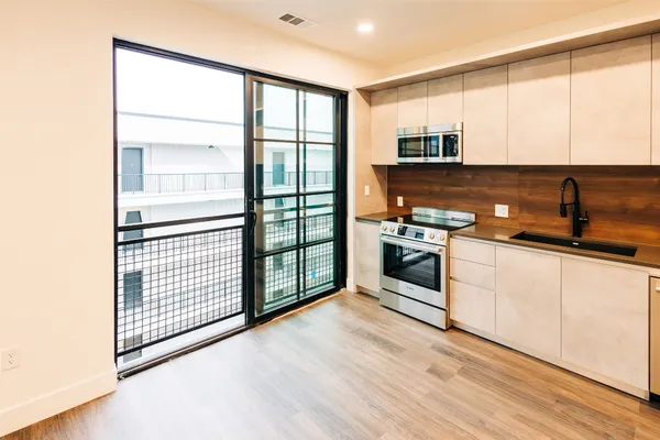 a kitchen with stainless steel appliances granite countertop a stove a sink and a microwave