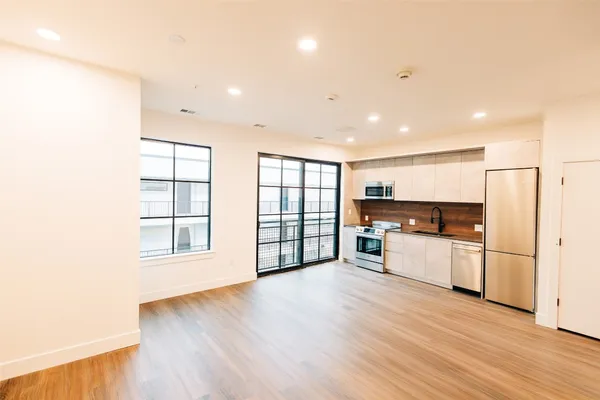 a kitchen with stainless steel appliances a refrigerator and wooden floor