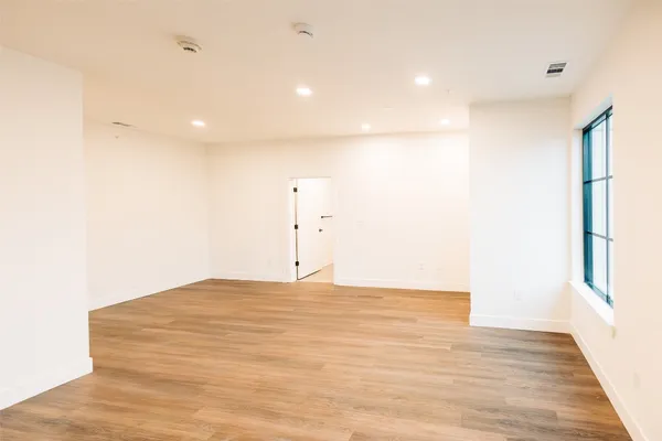 a view of an empty room with wooden floor