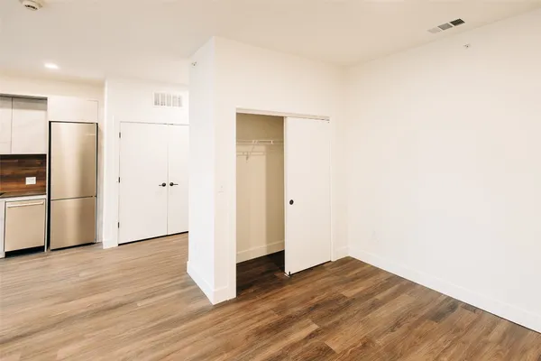 a view of empty room with wooden floor