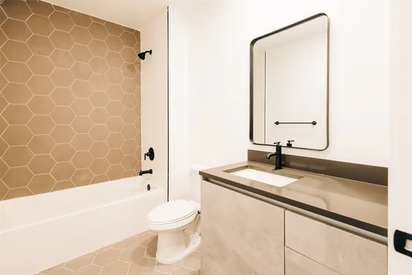 a bathroom with a granite countertop sink a toilet and a bathtub