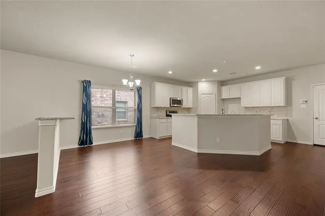 a living room with furniture a dining table and kitchen view with wooden floor