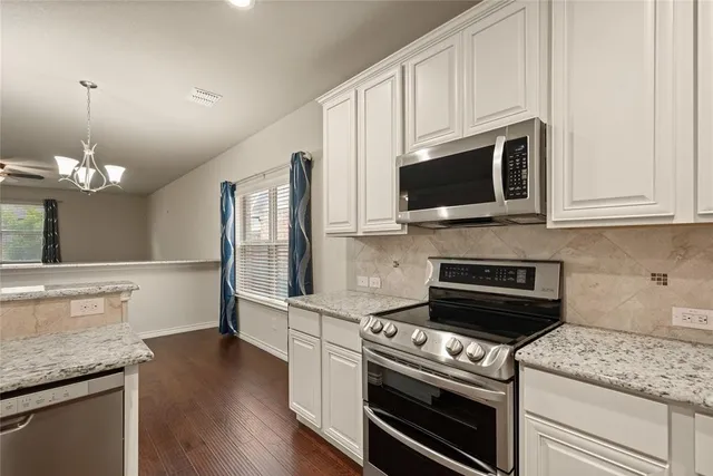a view of a kitchen with wooden floor and a window