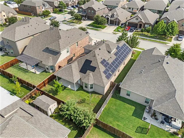 a view of a backyard with grass and a large tree