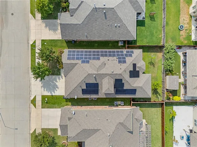 an aerial view of a house with a yard and lake