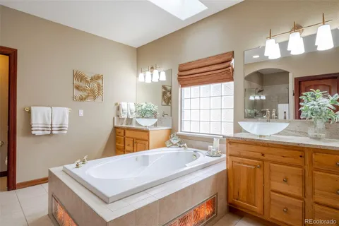 a bathroom with a tub sink and mirror