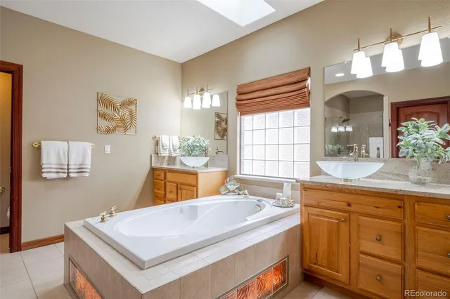 a bathroom with a tub sink and mirror