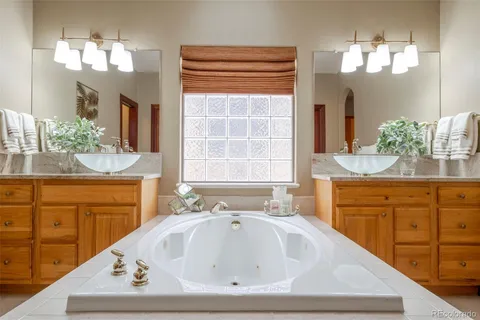 a bathroom with a sink a vanity a mirror and a bathtub