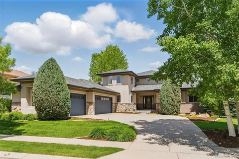a front view of a house with a garden and trees