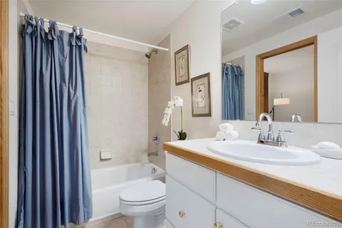 a bathroom with a sink a toilet a mirror and shower