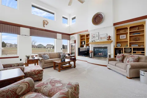 a living room with furniture fireplace and a large window