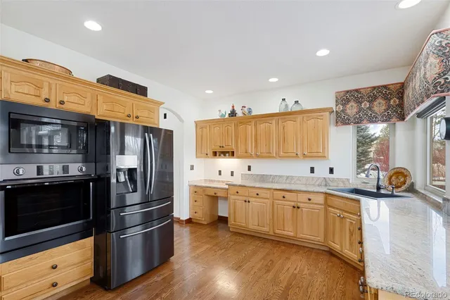 a kitchen with stainless steel appliances a sink a stove a refrigerator and cabinets