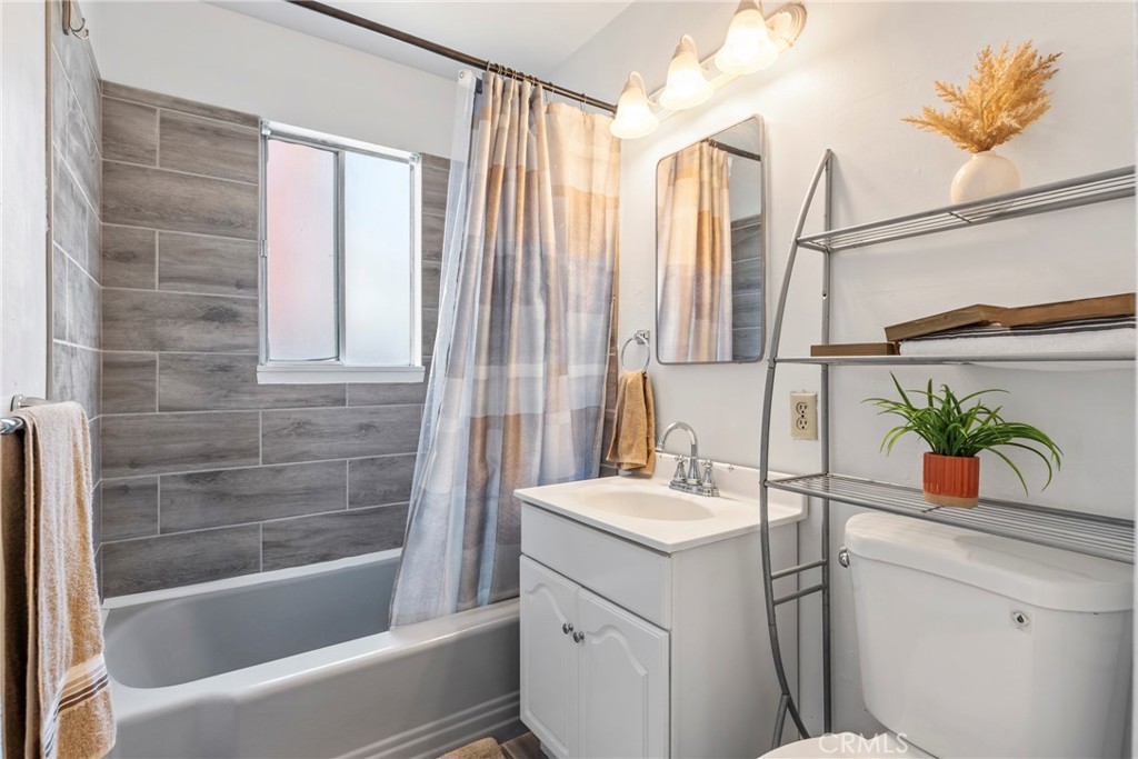 1510 High Street Atwater, CA 95301 - Photo 18 of 27 a bathroom with a sink a mirror a potted plant and a bathtub